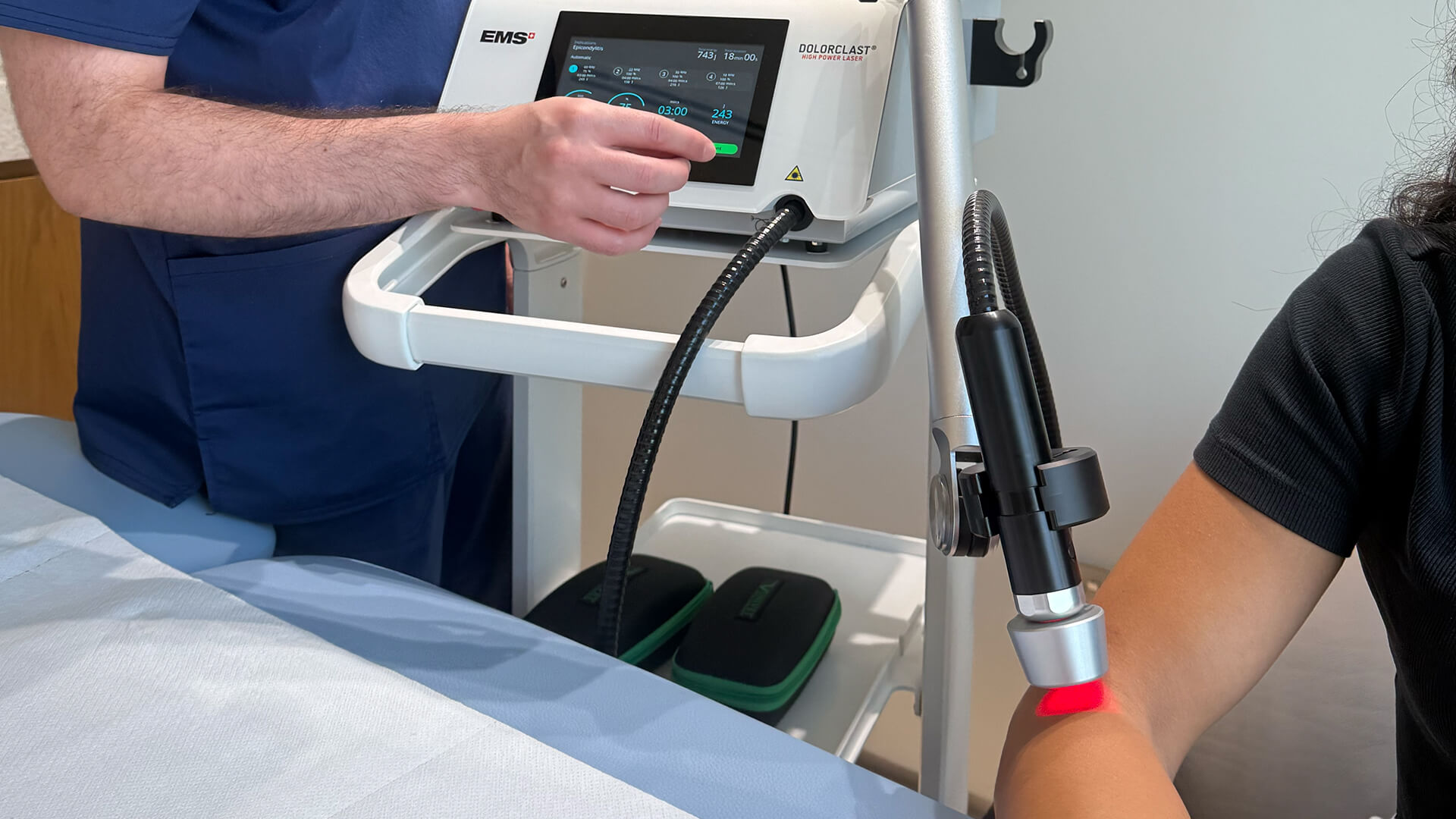 KINETIKA therapist performing laser therapy on patient