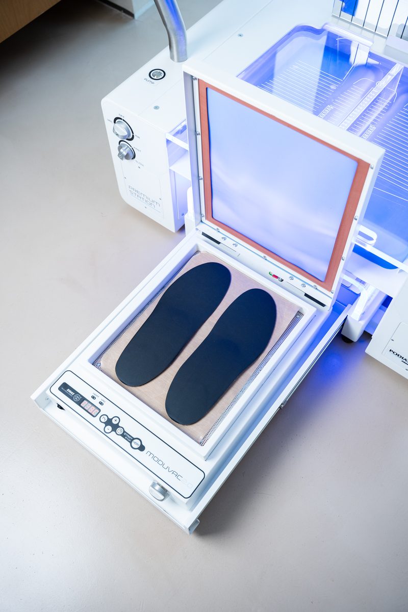 A pair of custom insoles being heat-moulded at KINETIKA Dubai Hills