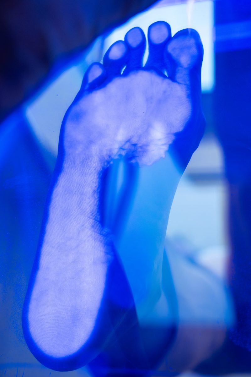 Foot on the glass podoscope showing where body weight lands during a custom insole assessment at KINETIKA